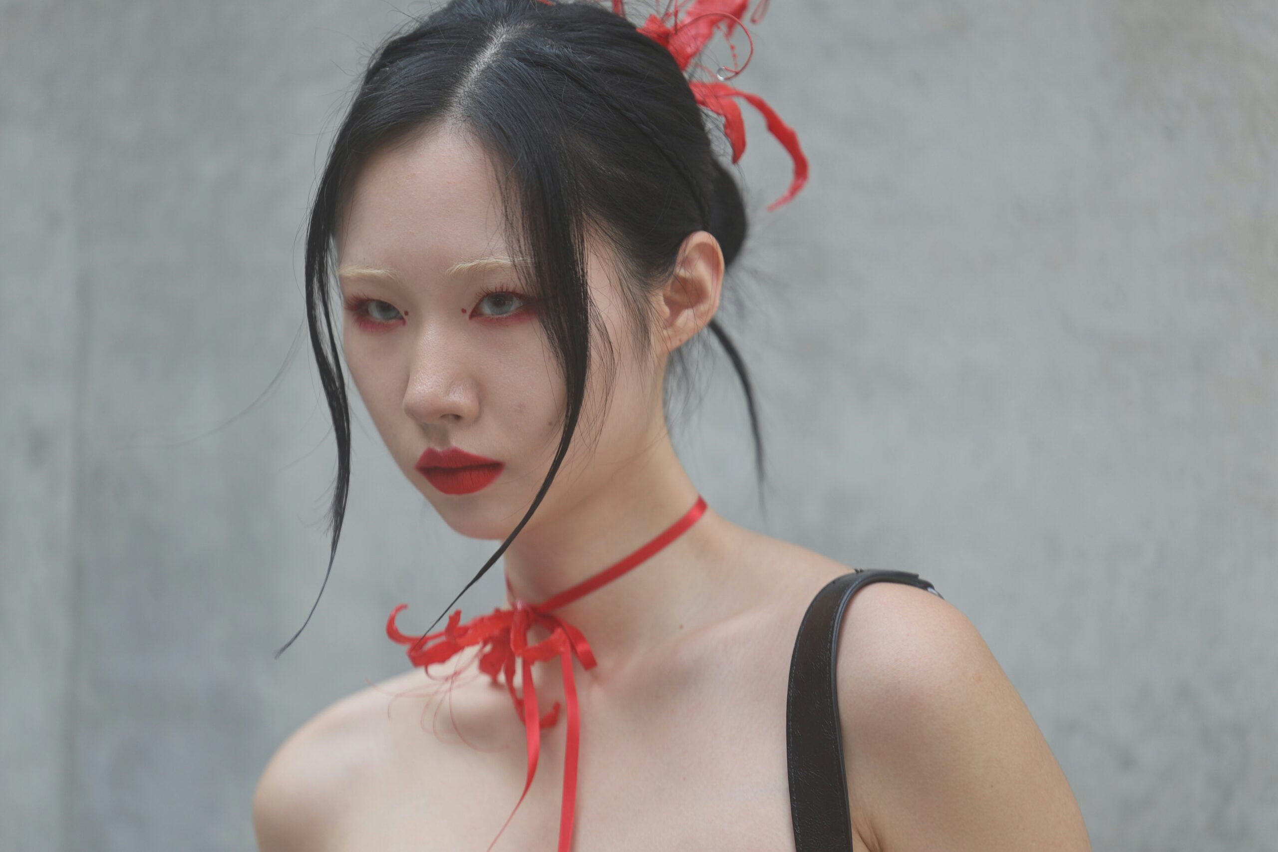 A model on the runway showcasing bold editorial makeup inspired by high-fashion design