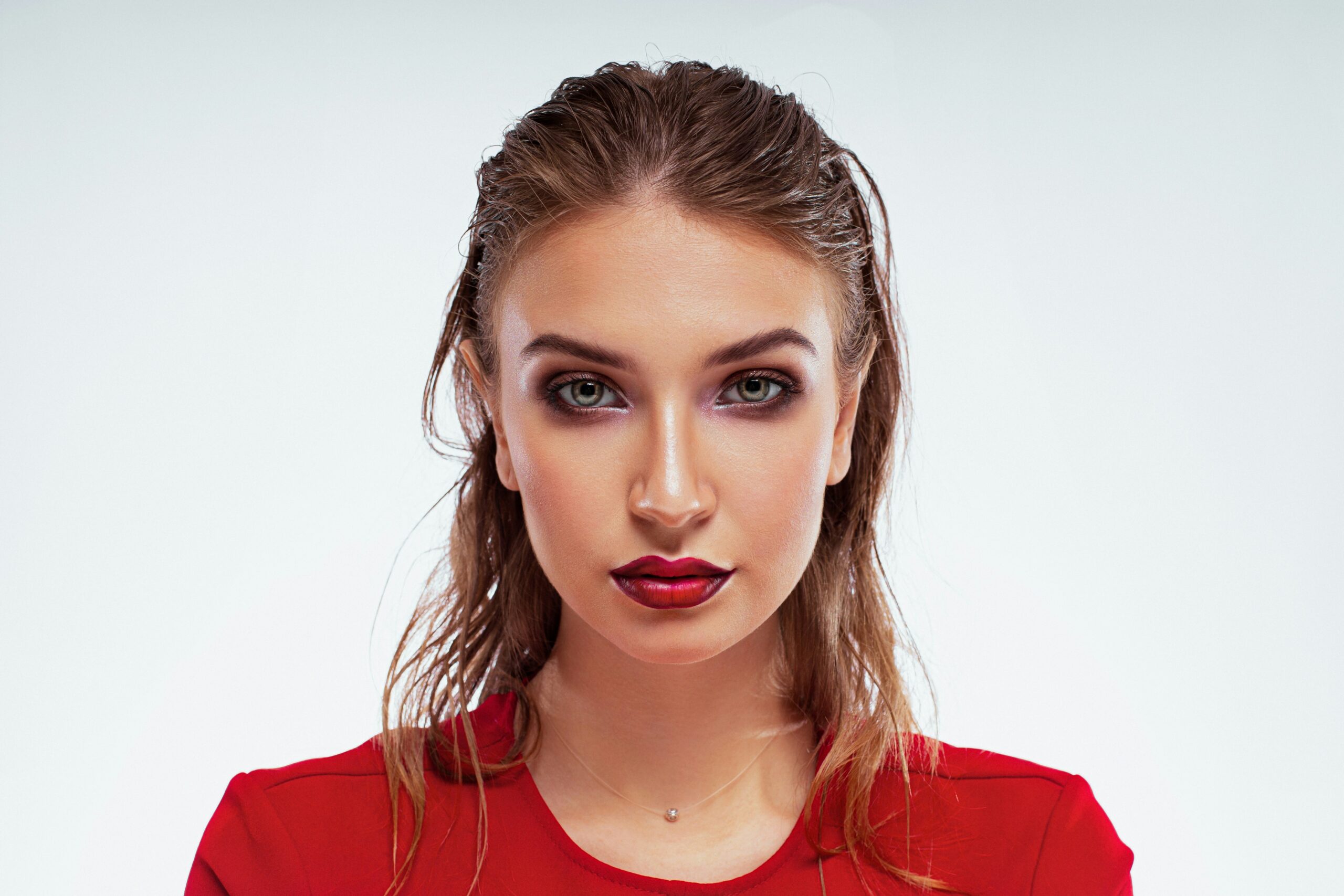 A model showcasing dramatic editorial makeup with bold lips and winged eyeliner