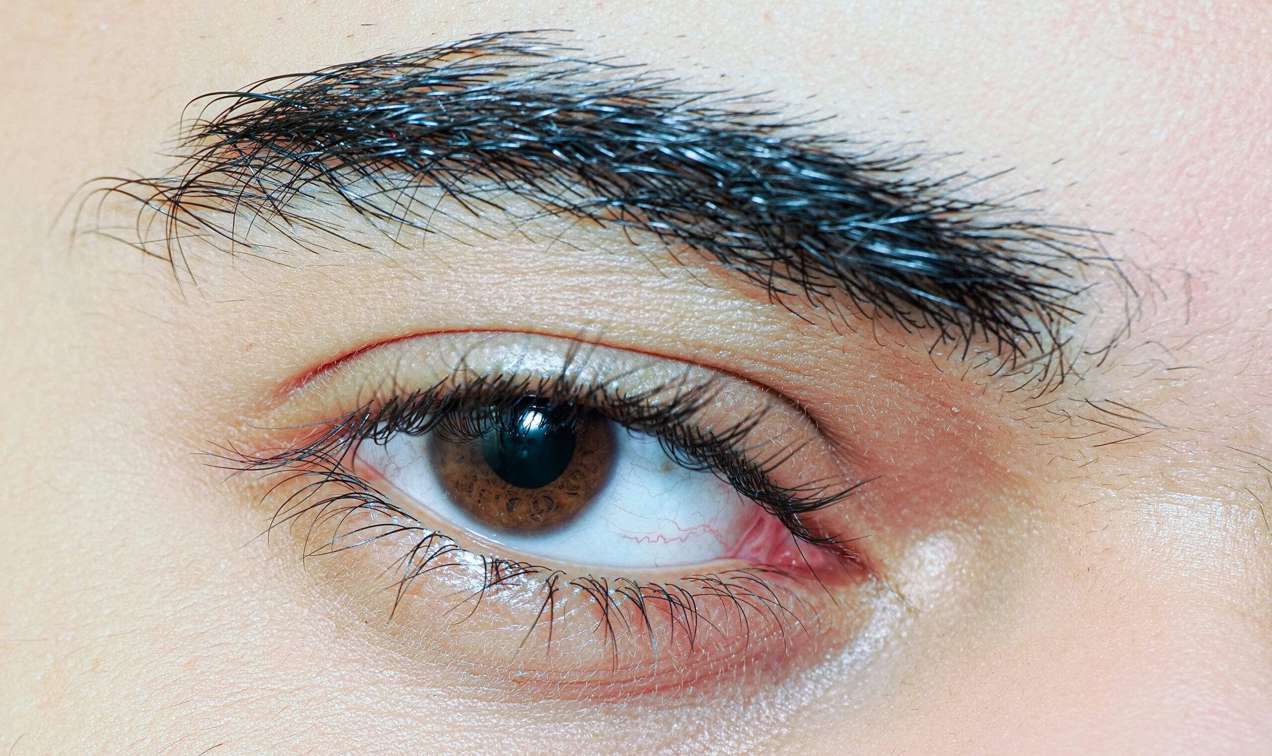 Close-up shot of glittery silver eyeliner applied dramatically along the upper lash line