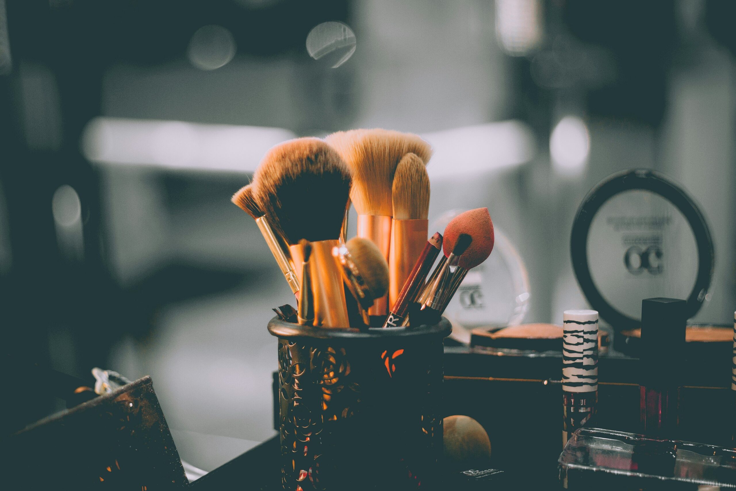 Close-up shot of brushes, palettes, and highlighters used for editorial makeup