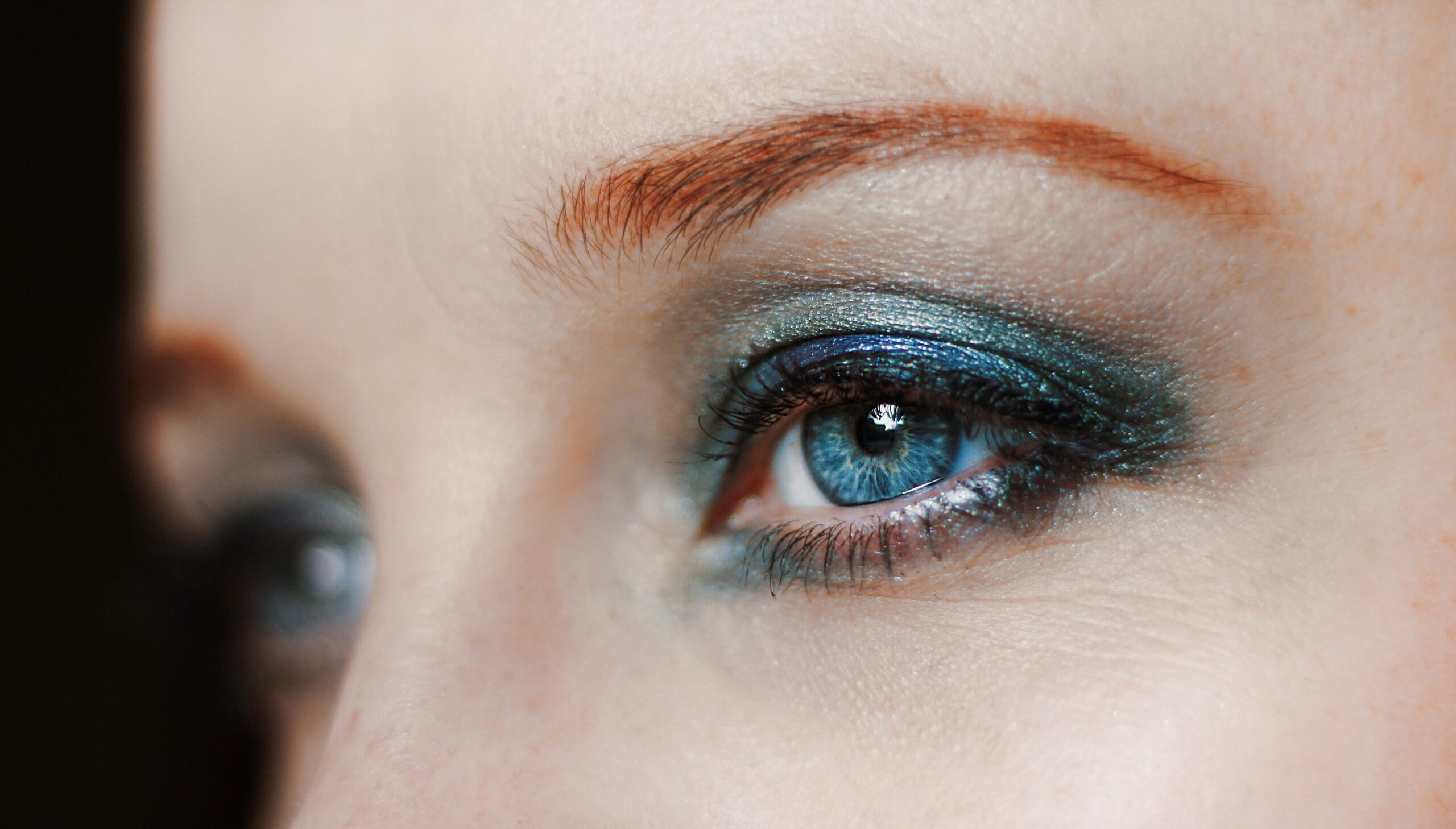 Model showcasing metallic foil eye makeup with shimmering gold accents