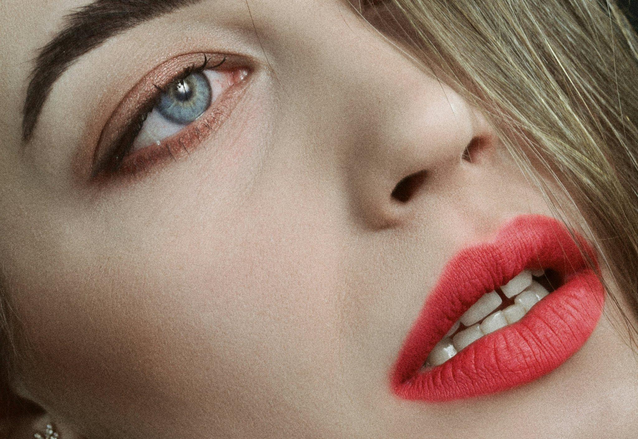An extreme close-up of a model's eye showcasing intricate graphic liner work and metallic shadow.