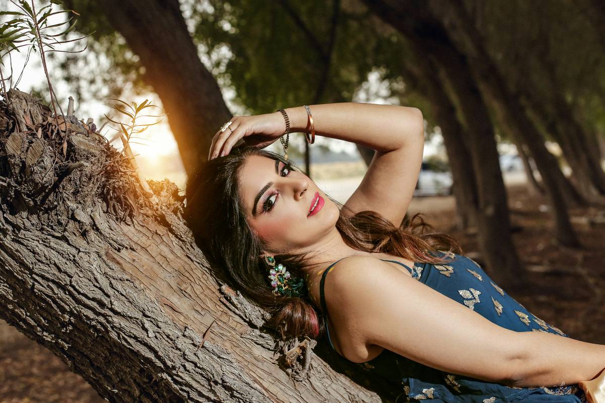 A model backstage wearing a bold blue cut-crease editorial eye look.