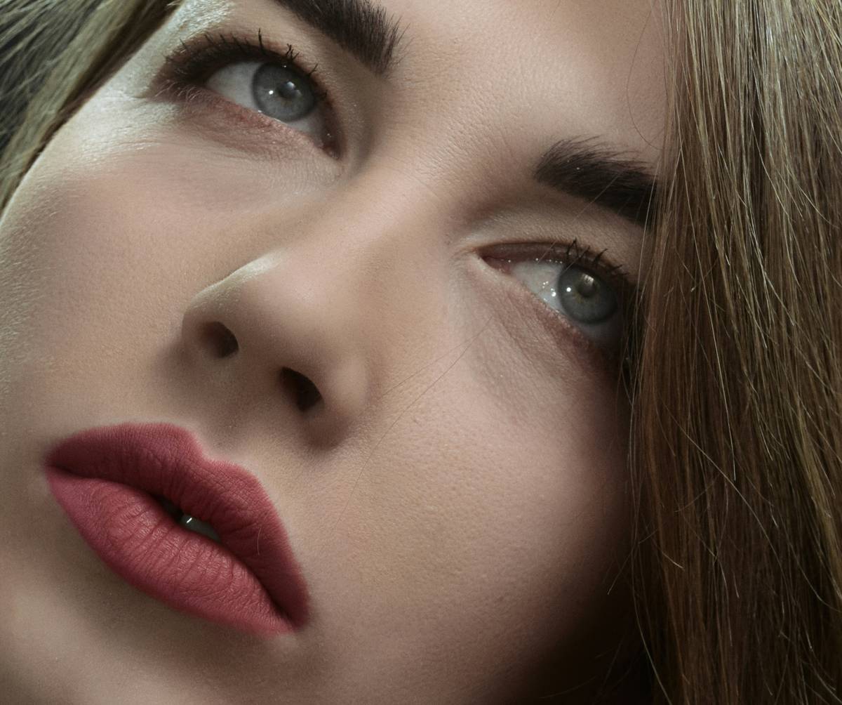 A model showcasing vibrant blue and silver futuristic lip art design.