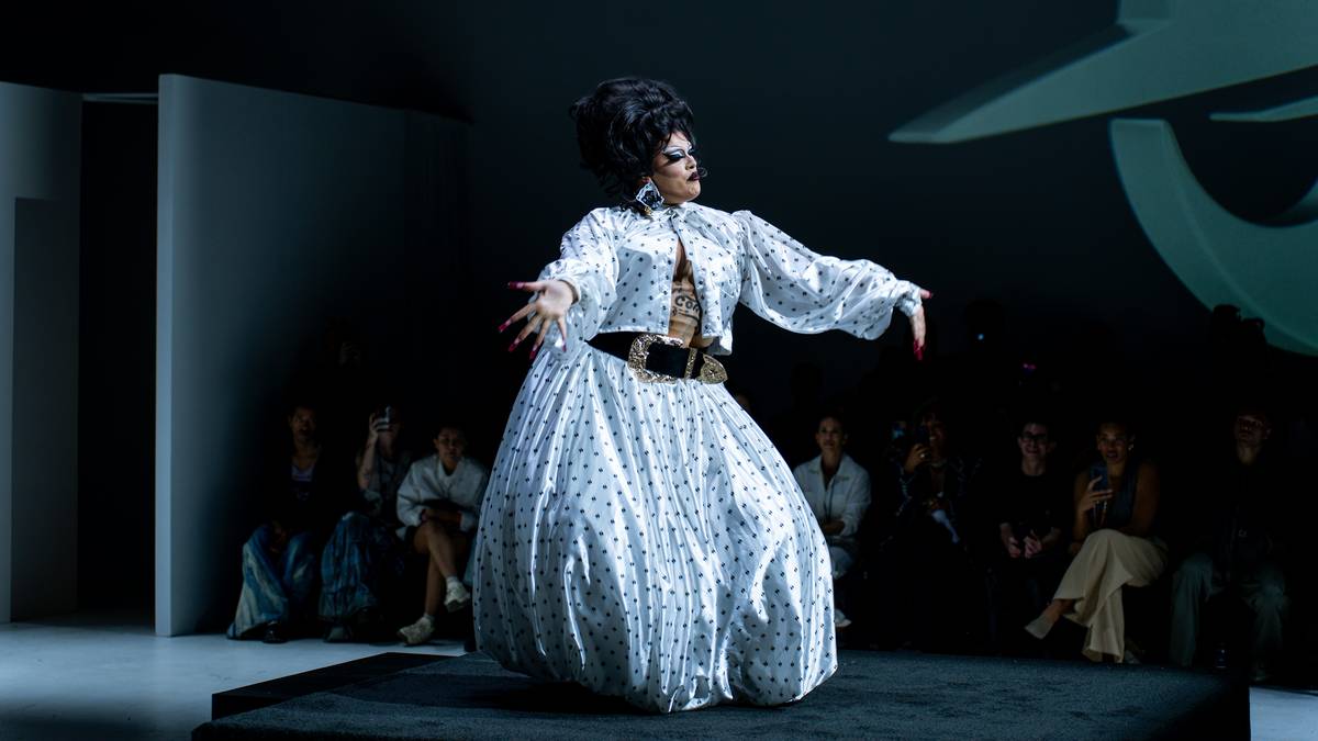 A model showcasing dramatic runway makeup with bold blue eyeshadow and sharp liner